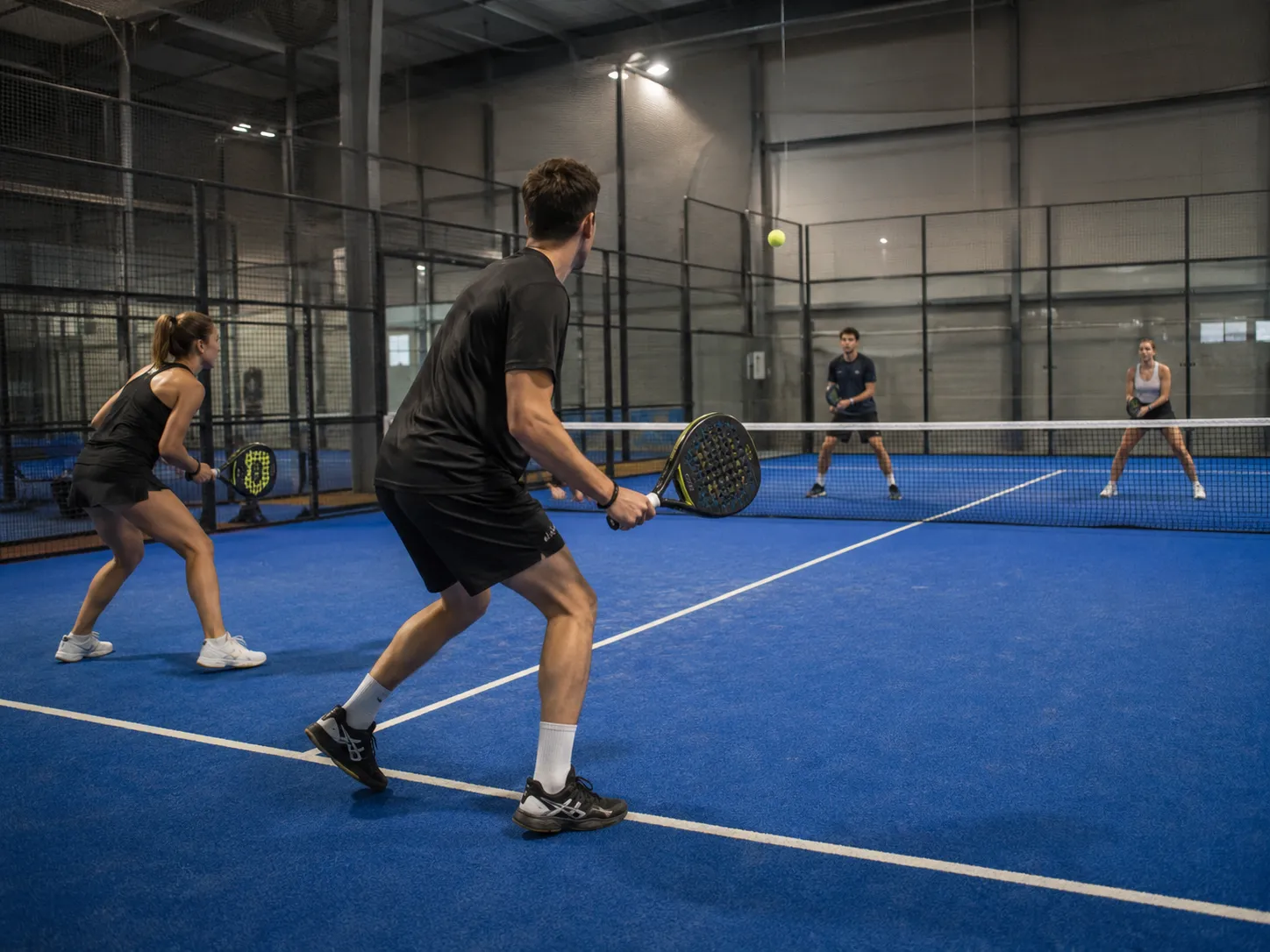 دو بازیکن در تور روی زمین Padel سرپوشیده